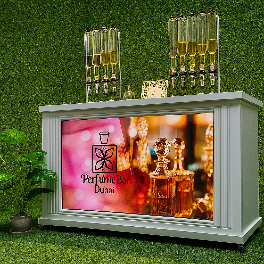 Perfume Booth setup in Dubai featuring a branded fragrance bar with colorful dispensers, interactive screen, and artificial grass backdrop for events and exhibitions